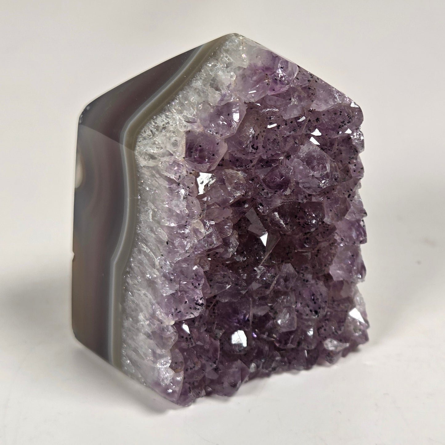 Agate with amethyst tower colorful bands of chalcedony agate on a white background