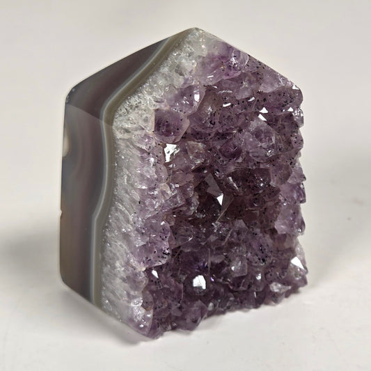 Agate with amethyst tower colorful bands of chalcedony agate on a white background