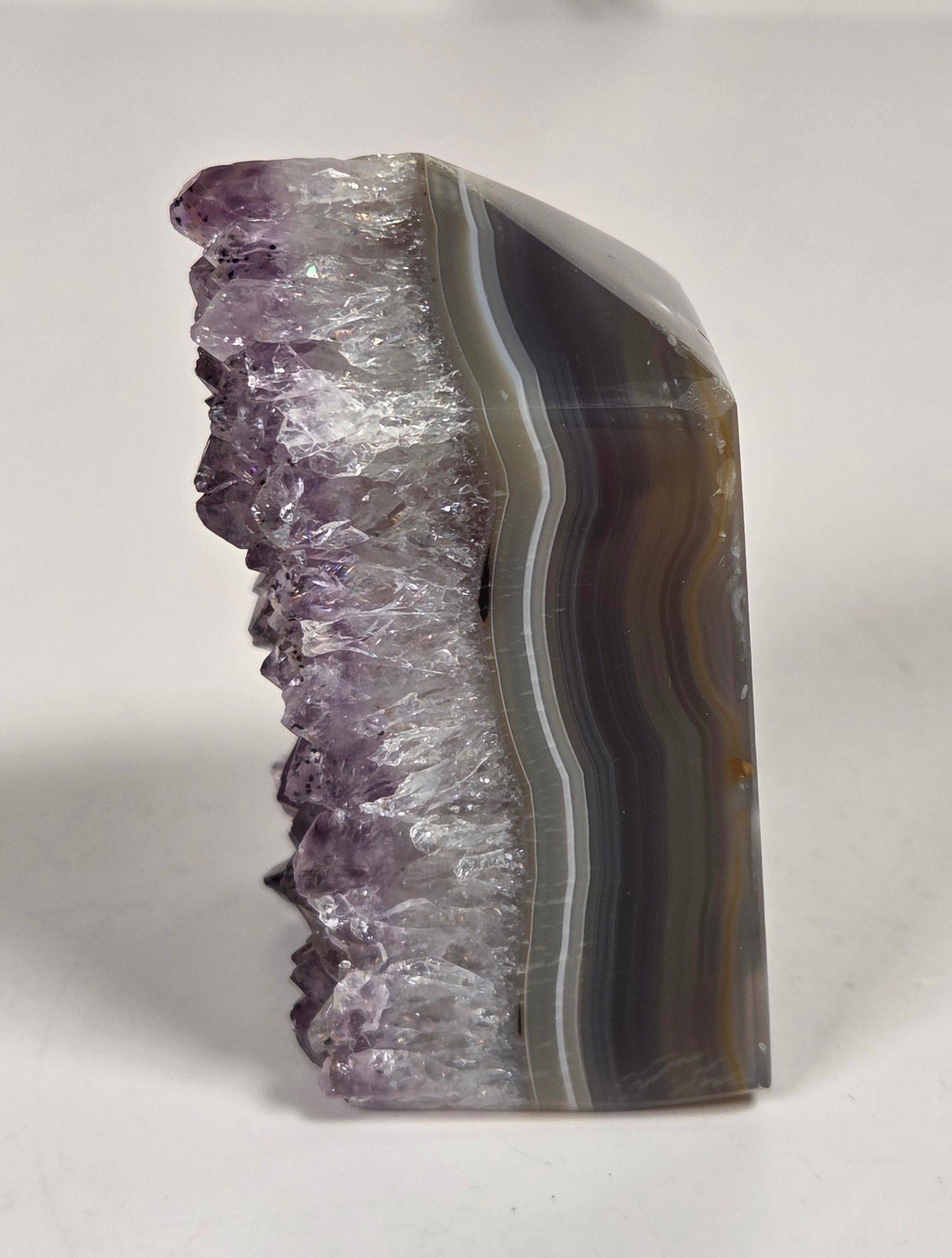Agate with amethyst tower colorful bands of chalcedony agate on a white background