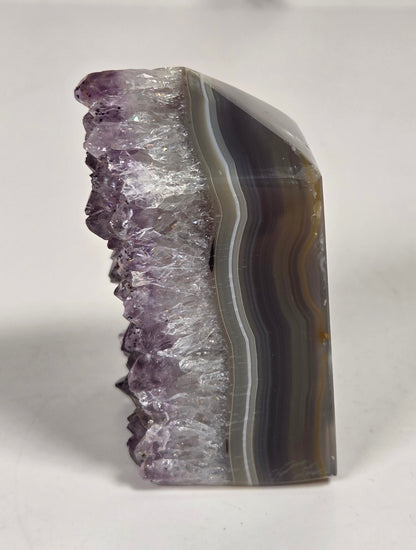 Agate with amethyst tower colorful bands of chalcedony agate on a white background