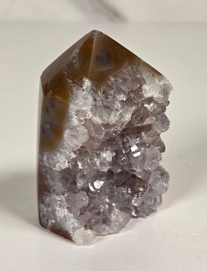 Agate with amethyst tower colorful bands of chalcedony agate on a white background