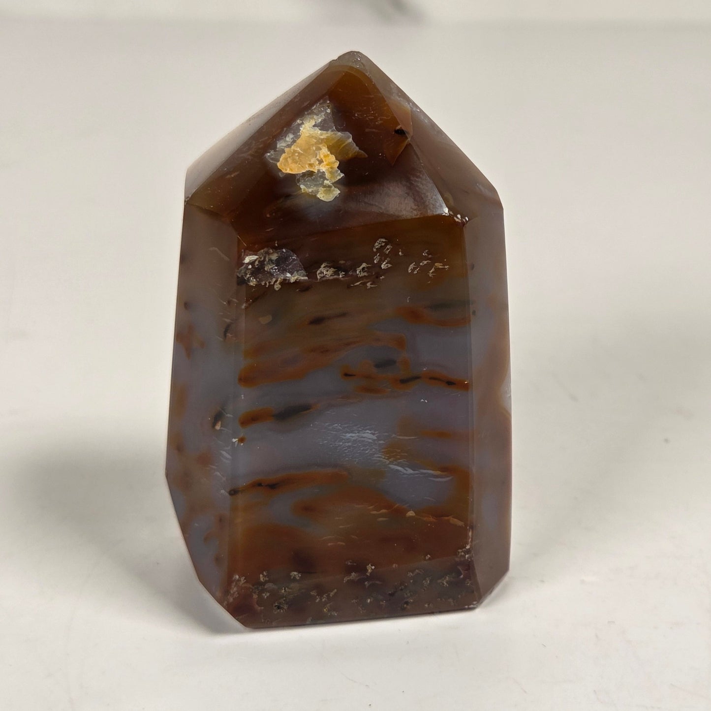 Agate with amethyst tower colorful bands of chalcedony agate on a white background