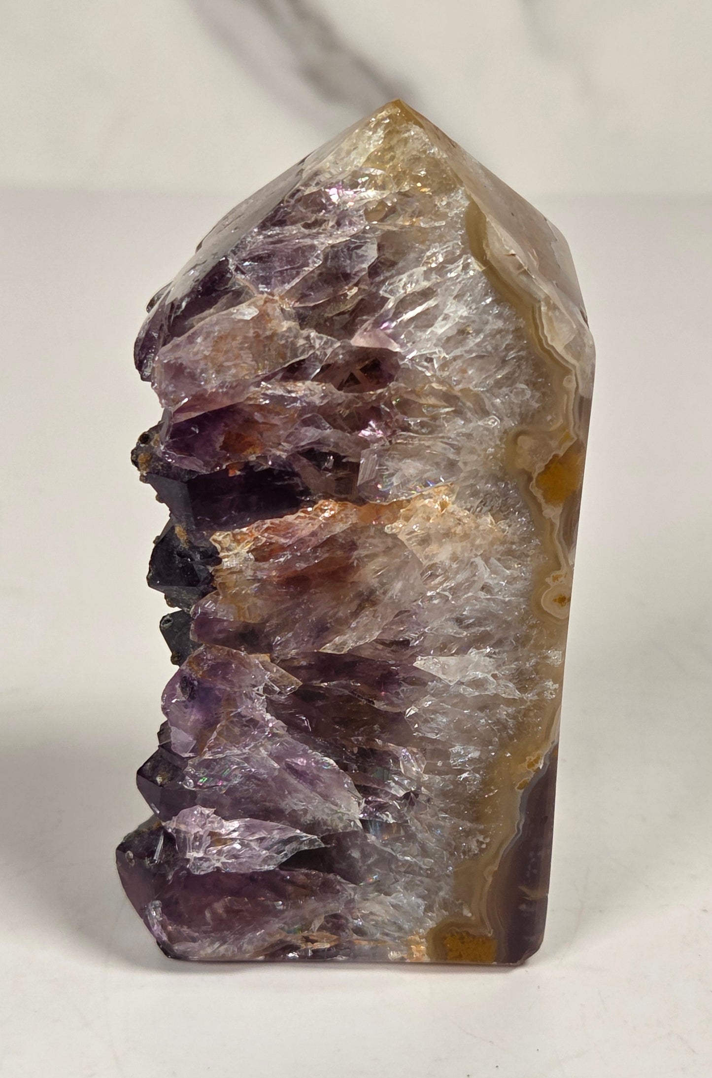 Agate with amethyst tower colorful bands of chalcedony agate on a white background