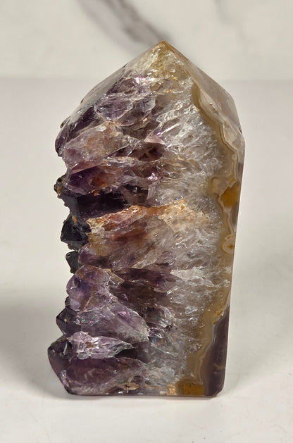 Agate with amethyst tower colorful bands of chalcedony agate on a white background
