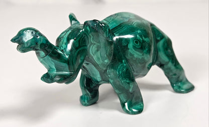 Green malachite crystal carved into the shape of an elephant against a white background