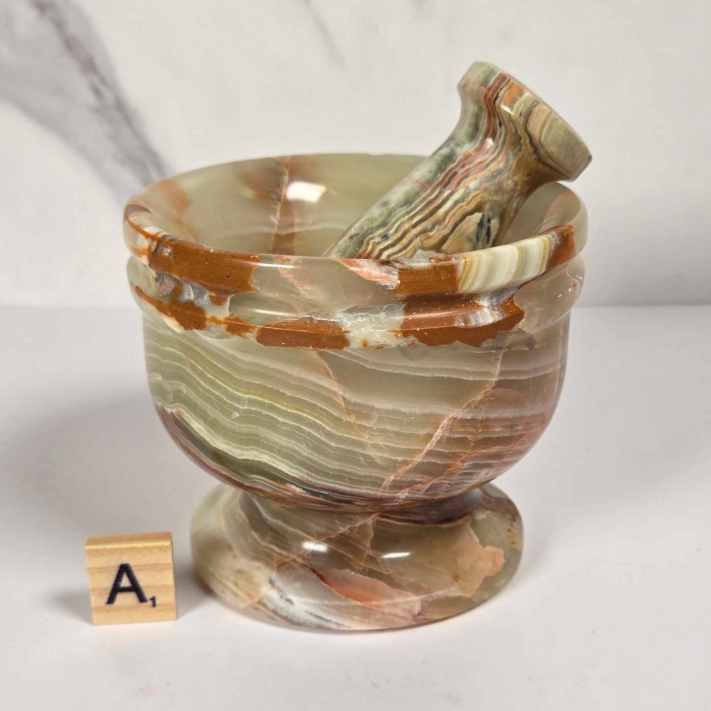 Afghan Onyx pestle and mortar set on a white surface with a gray background