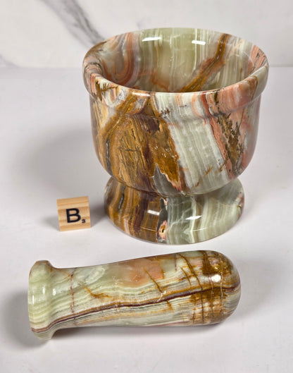 Afghan Onyx pestle and mortar set on a white surface with a gray background