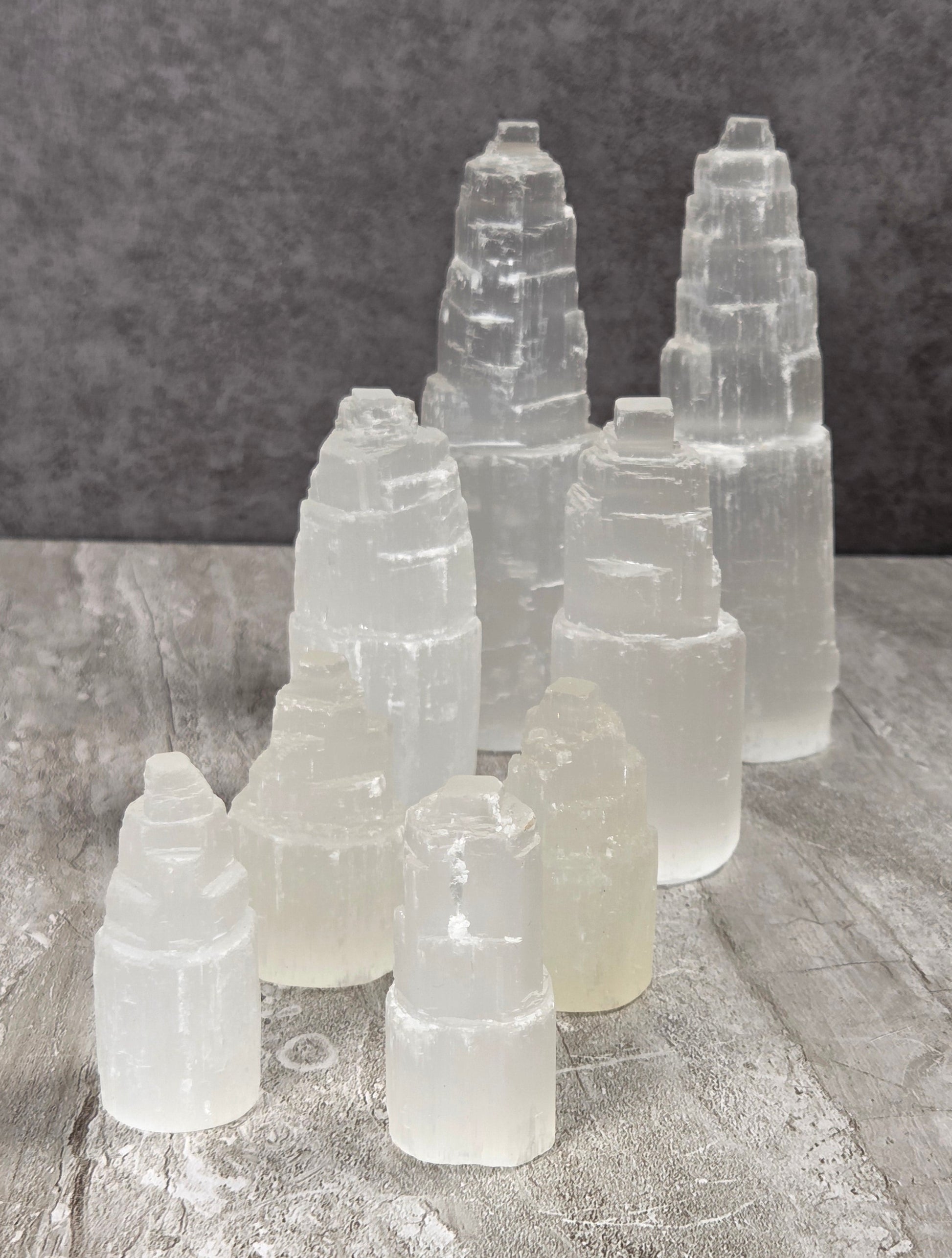 Selenite towers in various sizes against a grey background