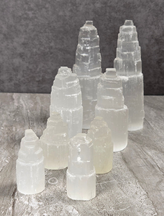 Selenite towers in various sizes against a grey background