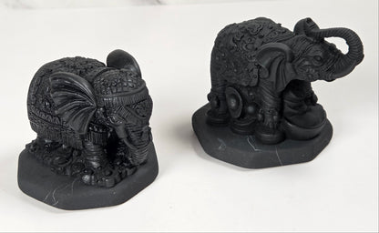 Shungite carving of two elepahants on a white background