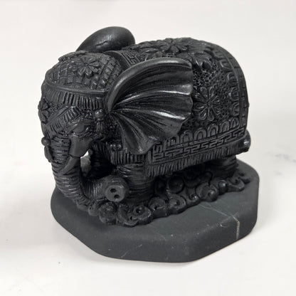 Shungite carving of two elepahants on a white background