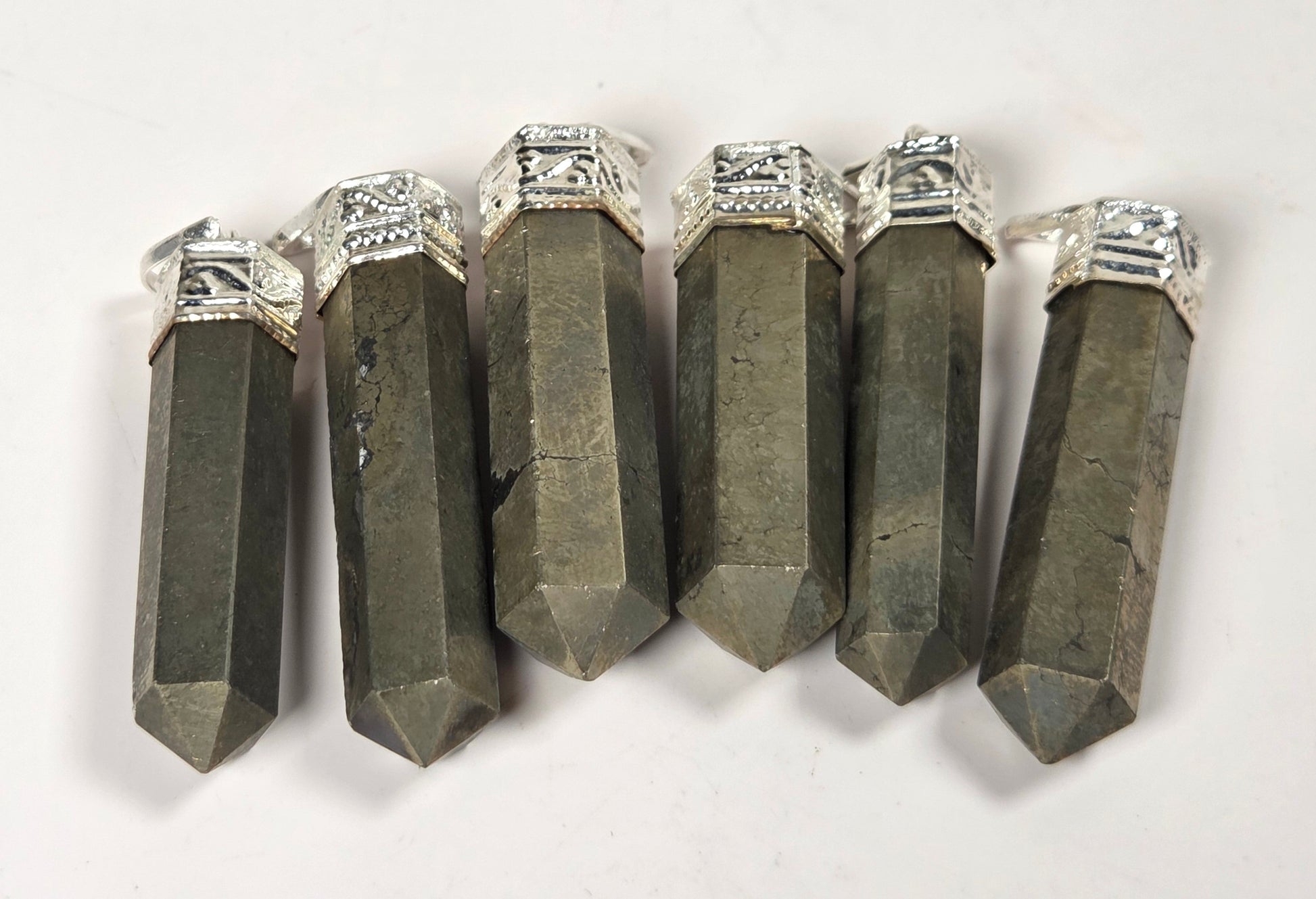 Five dark gray crystal point pendants with silver-toned metal caps, arranged side by side on a plain white background.