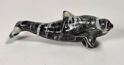 A polished black and white marbled stone dolphin figurine, displayed on a plain light gray background.