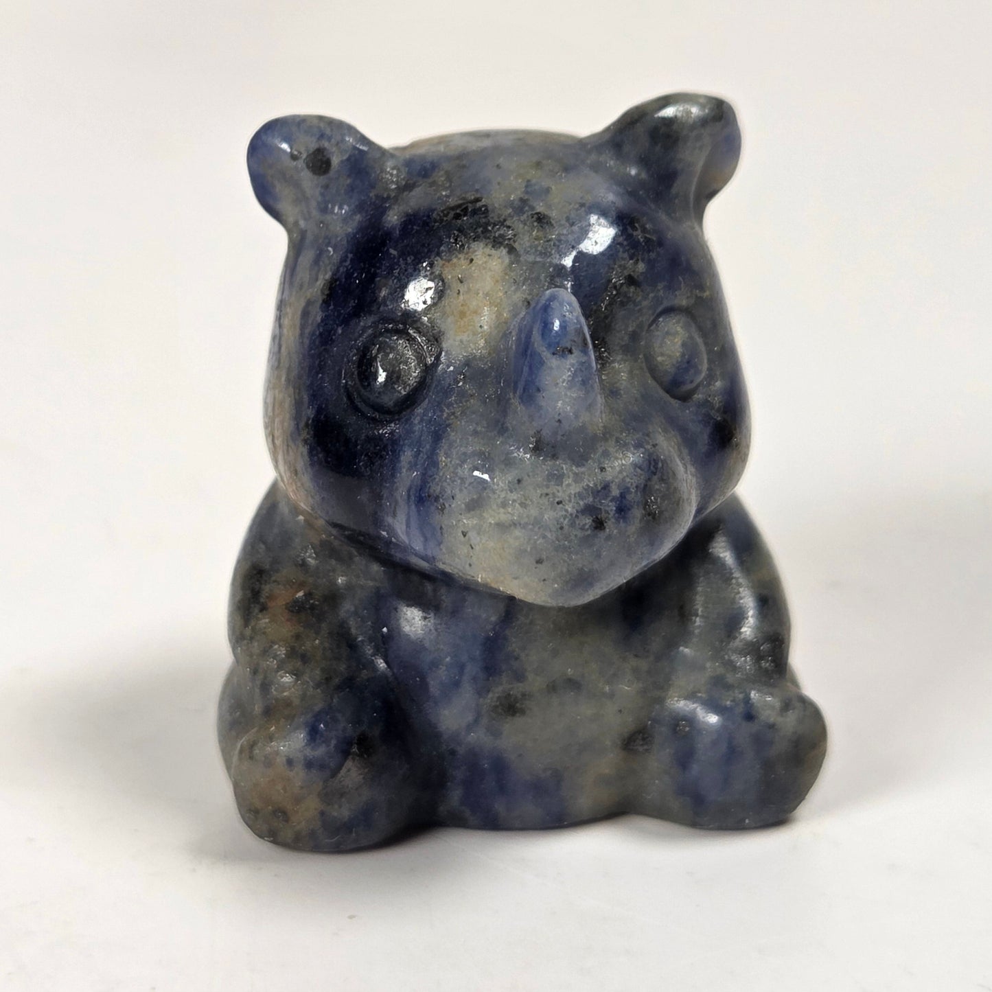 A small carved rhinoceros figurine made of polished blue-gray stone, shown on a plain light background.