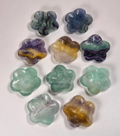 Nine carved gemstone flower-shaped bowls in various colors and patterns, arranged on a plain white background.