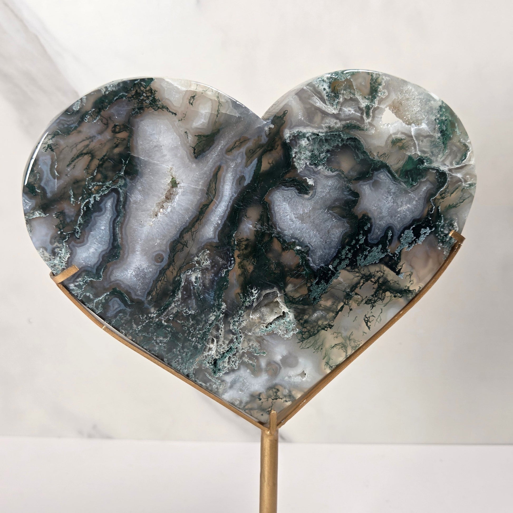 Heart-shaped agate stone wall plaque on a gold metal stand, featuring natural agate patterns in green, gray, and white.