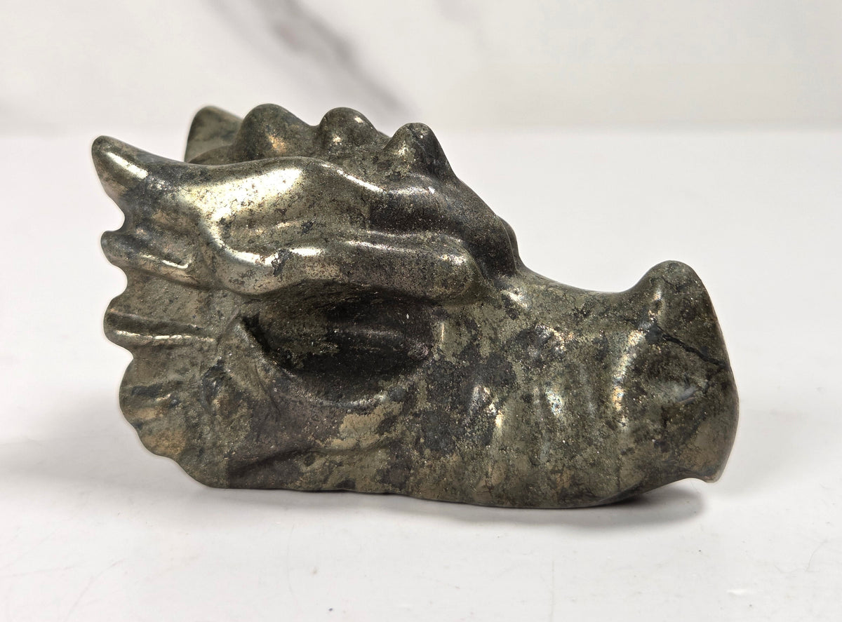 Pyrite dragon head carving on a white background