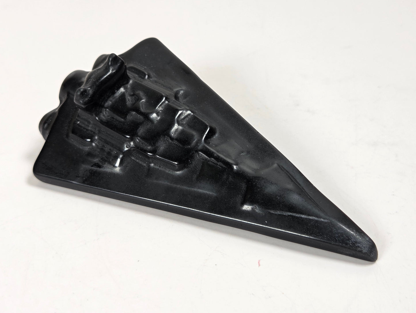 Obsidian carving of a Star Wars ship on a white background