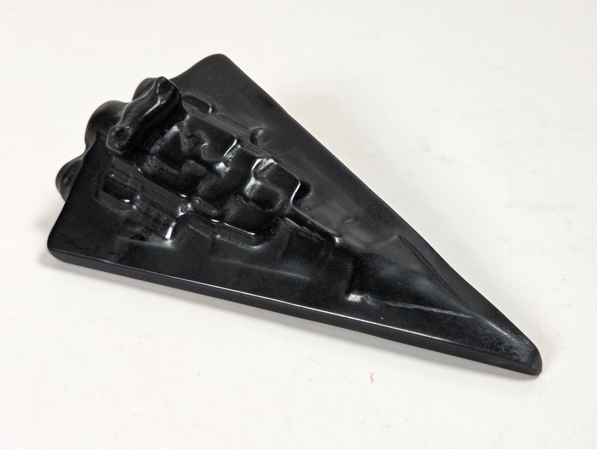 Obsidian carving of a Star Wars ship on a white background