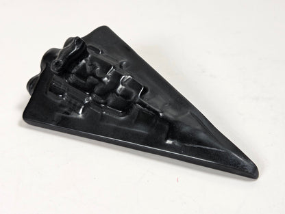 Obsidian carving of a Star Wars ship on a white background