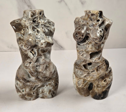 Druzy quartz carved female torsos against a white background