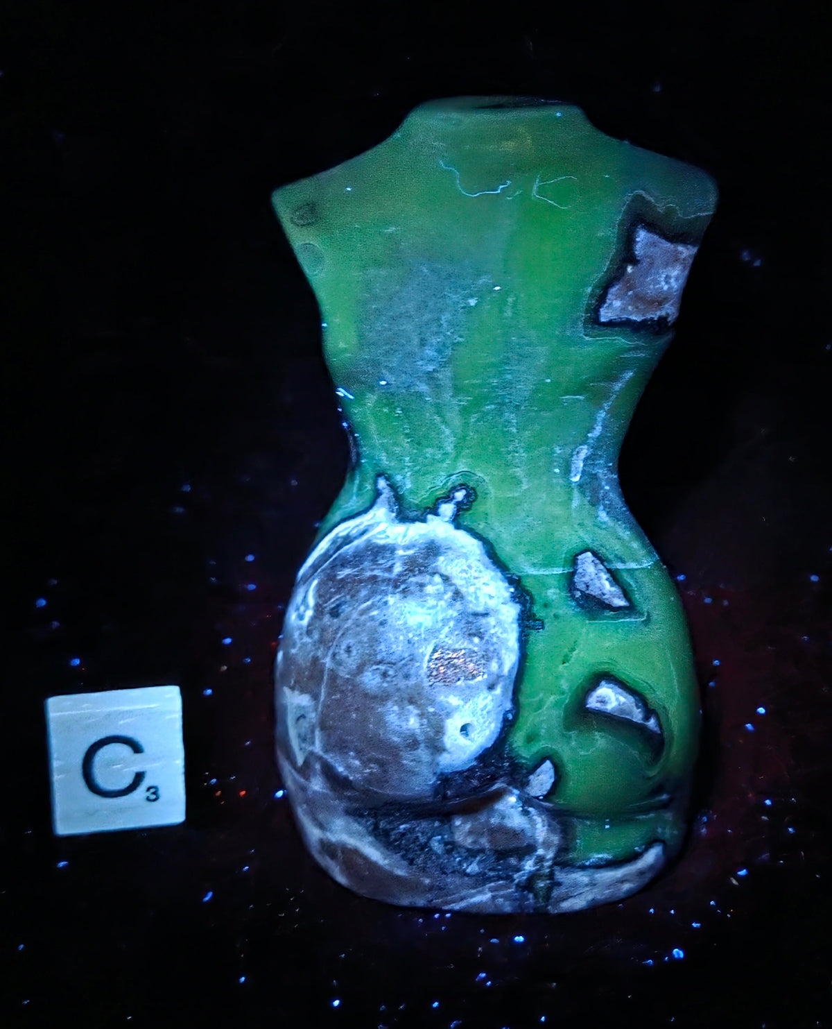 A green and white textured ceramic vase with a hand-painted distressed pattern, displayed on a black background with a small white tile showing the letter 'C' and '9' next to it.