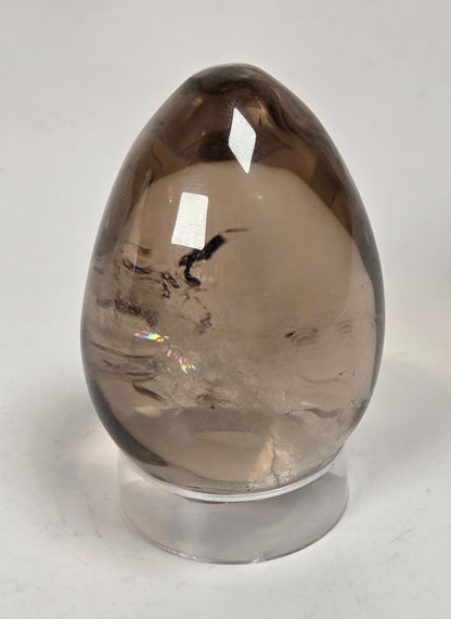 A teardrop-shaped smoky quartz crystal ornament on a clear acrylic display stand, set against a plain white background.