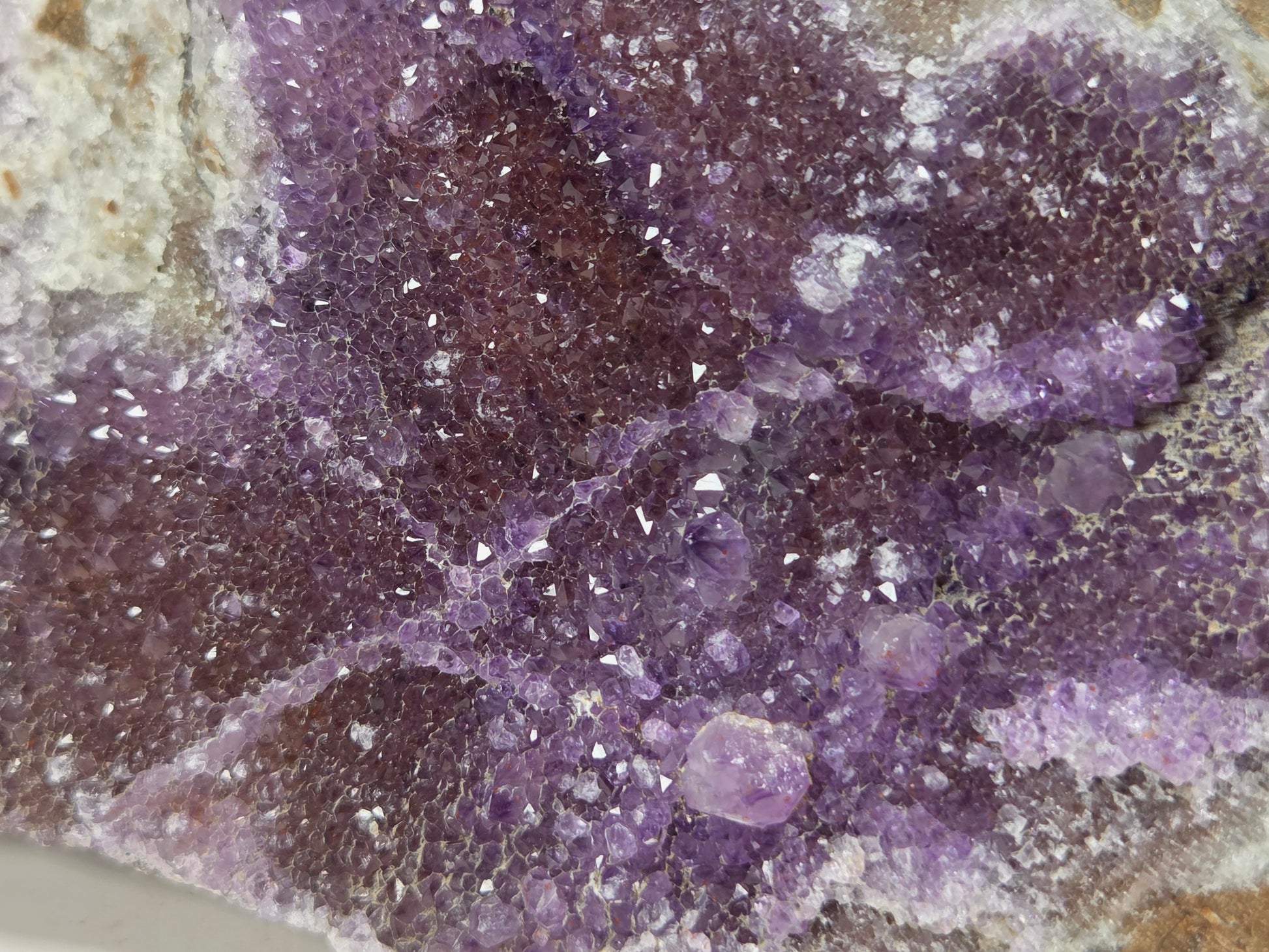Close-up of a purple mineral specimen or crystal cluster with a textured, crystalline surface and some lighter translucent areas.