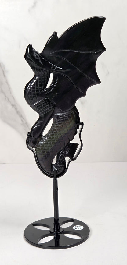 A black dragon figurine with detailed scales and wings, mounted on a black metal stand with a circular base, set against a white marble-patterned background.