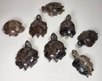 A set of nine carved stone turtle figurines in various poses, displayed on a plain light gray background.