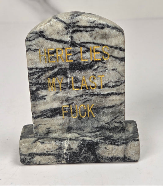 Spiderweb Jasper tombstone carving with gold lettering against a white background