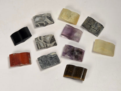 A set of ten small rectangular polished stone pieces in various colors and patterns, arranged on a plain white background.