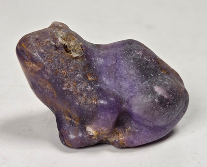 purple crystal frog carving against a white background