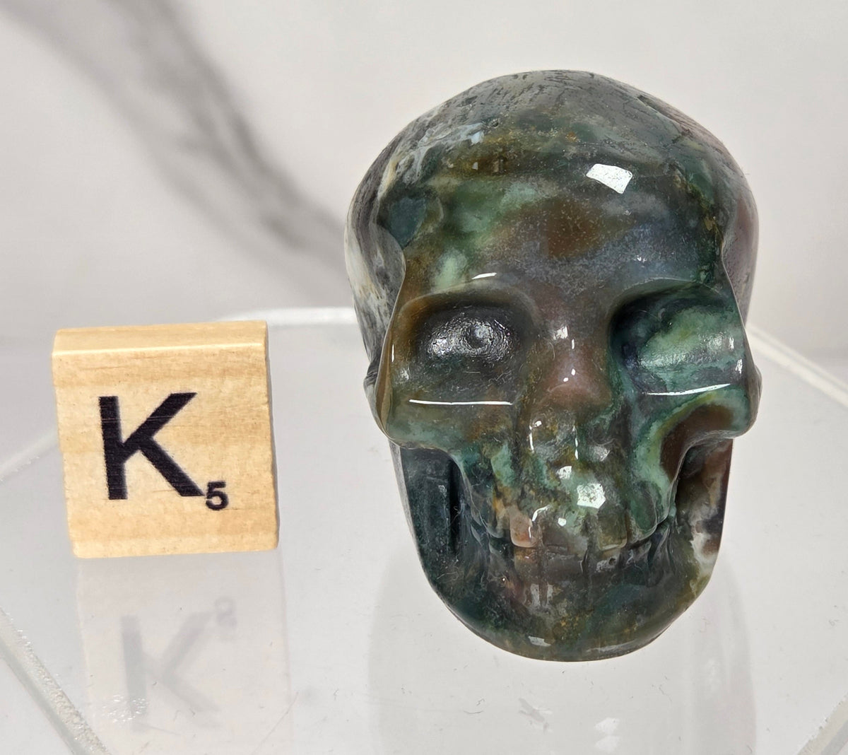 Moss Agate skull carving on a white background