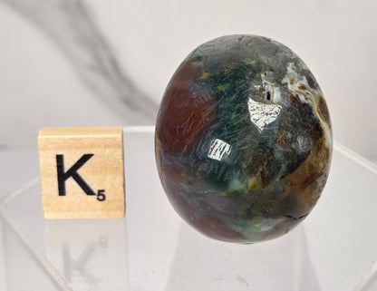 Moss Agate skull carving on a white background