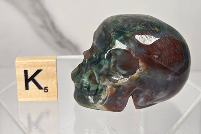 Moss Agate skull carving on a white background