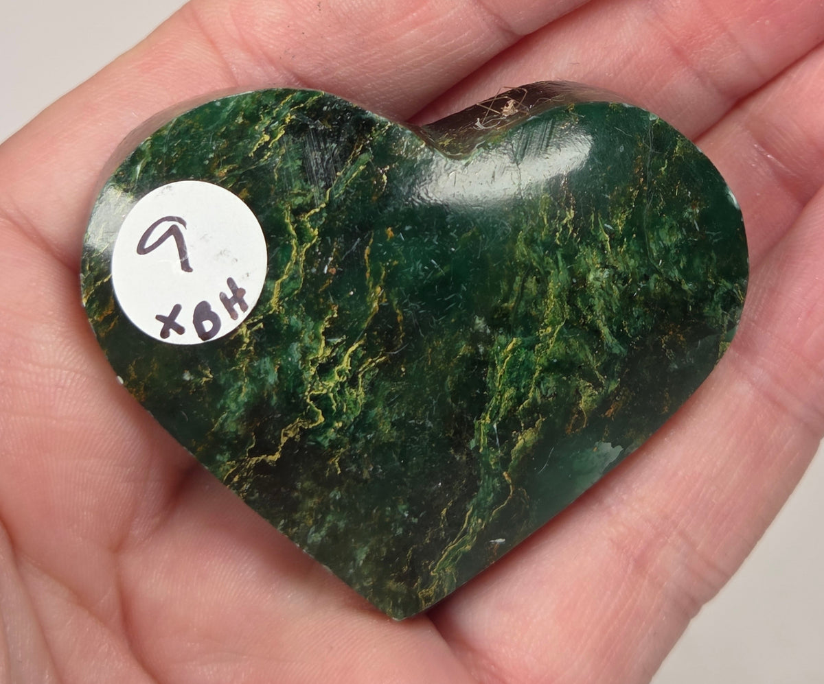 Heart-shaped green stone being held in a hand