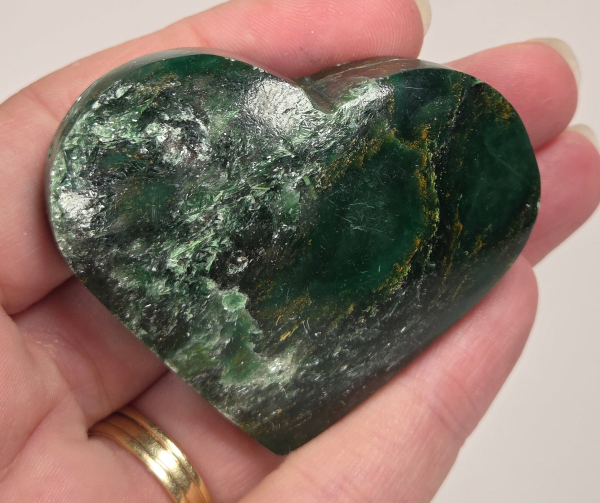 Heart-shaped green stone being held in a hand