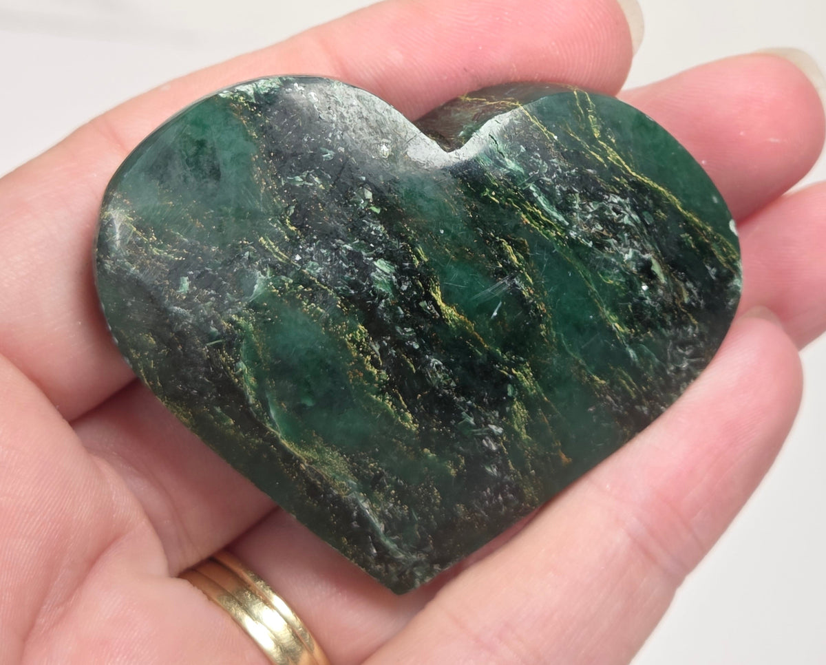 Heart-shaped green stone being held in a hand