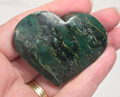 Heart-shaped green stone being held in a hand