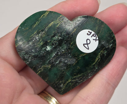 Heart-shaped green stone being held in a hand