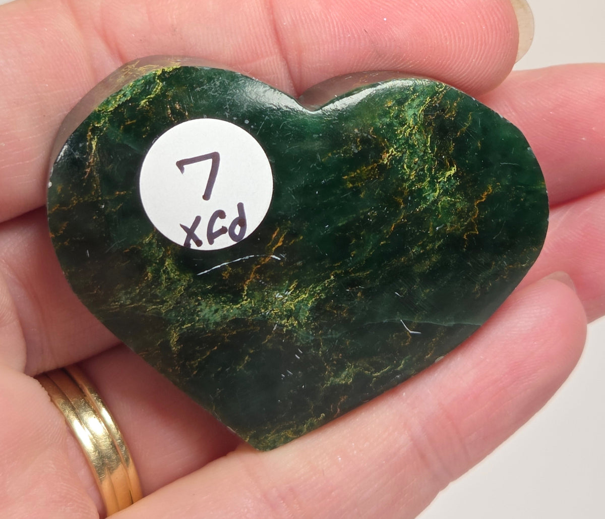 Heart-shaped green stone being held in a hand