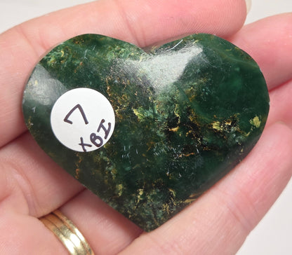 Heart-shaped green stone being held in a hand