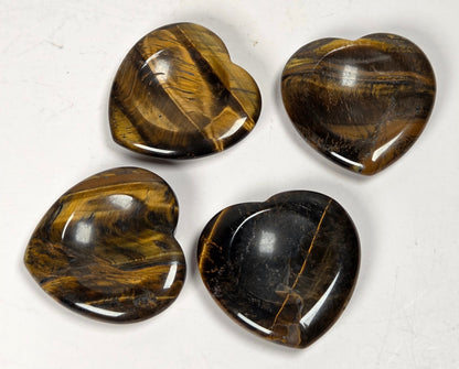Heart shaped tigers eye carvings against a white background