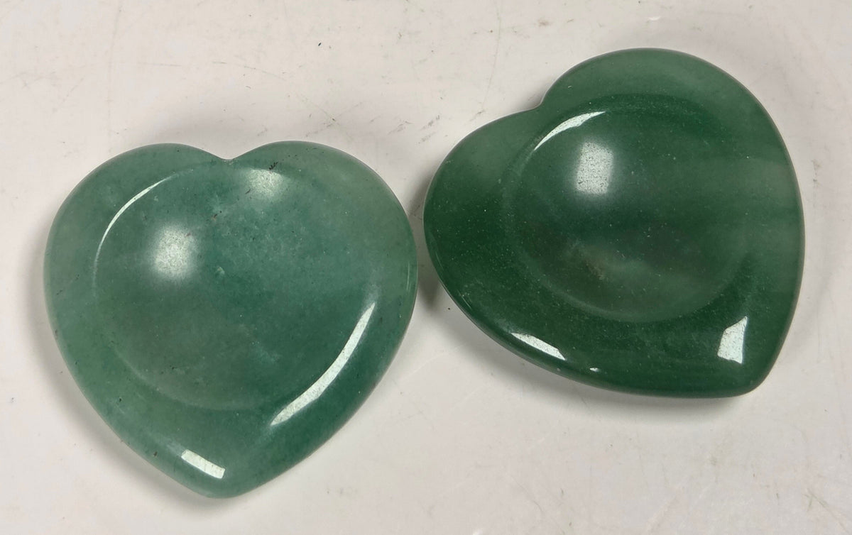 heart shaped green aventurine crystal carvings against a white background