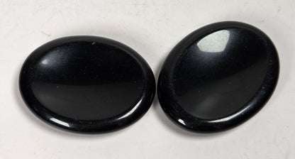 obsidian crystal carvings against a white background