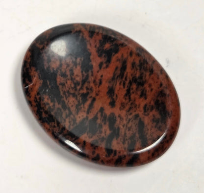 mahogany obsidian crystal carving against a white background