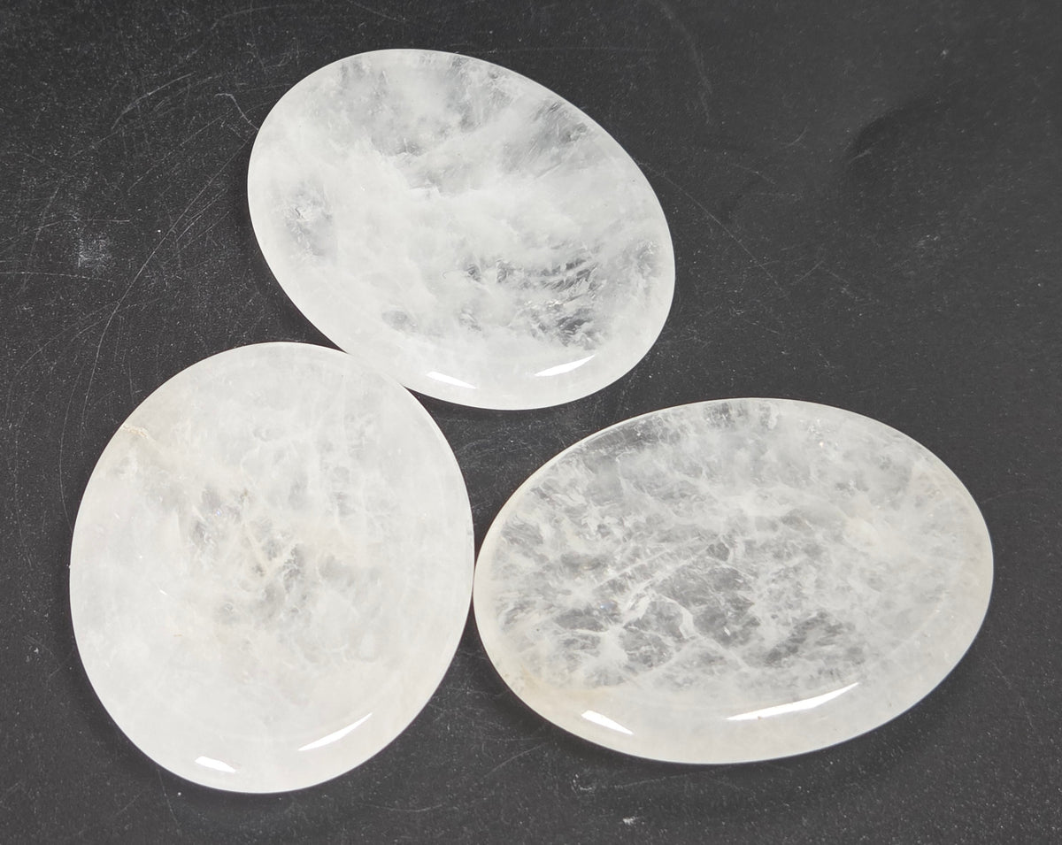 clear quartz crystal carvings against a white background