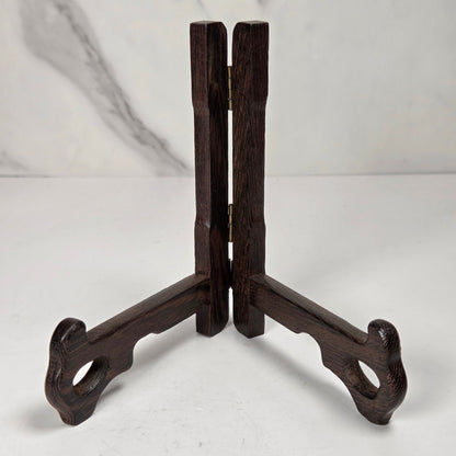 Dark wooden stand on a white surface with a marble-patterned wall in the background