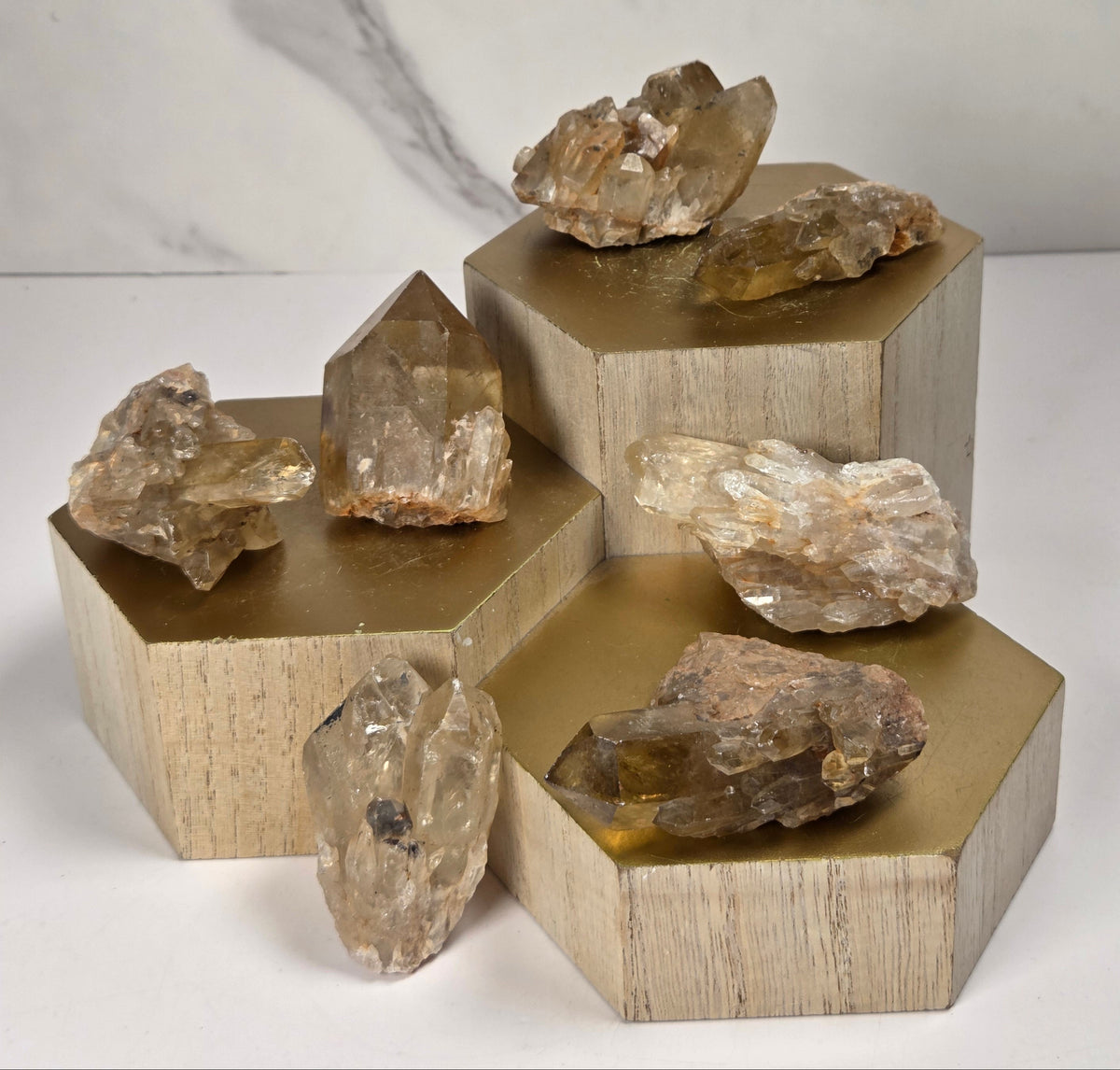 collection of citrine specimens on a wood base against a marbled white background